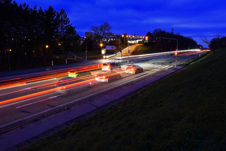 道路上的夜间照片交通。晚上风景与汽车。车灯和模糊色线的汽车