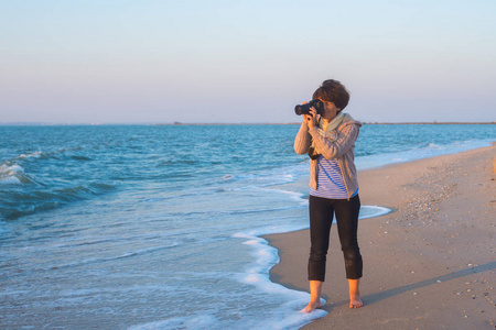 女摄影师在海边拍照片