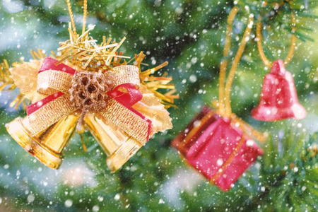 圣诞丝带铃铛和装饰品装饰挂在树上雪效果和添加颜色滤镜
