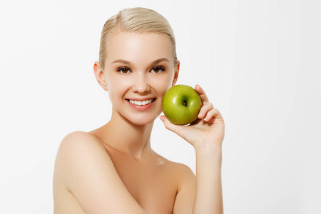 健康饮食食品。美丽快乐微笑的年轻女子特写肖像, 洁白的牙齿和新鲜的脸捧着有机绿色的苹果。牙科健康概念。高分辨率图像