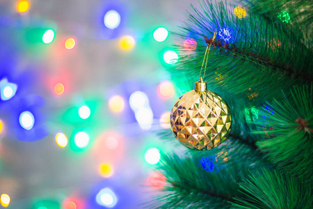 圣诞金球在圣诞树上的花环的闪光的背景下, 散