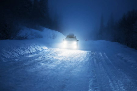 汽车的灯光在冬季森林