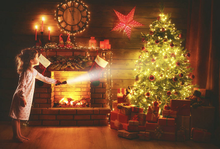 圣诞夜小女孩在晚上看着手电筒