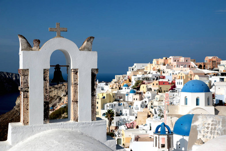 视图的海面通过传统希腊白色教堂拱与交叉和响铃在伊亚基克拉迪村岛，希腊圣托里尼