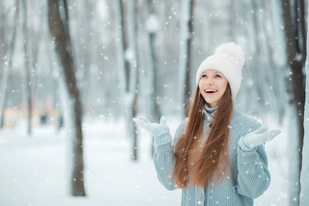 户外特写照片, 年轻漂亮的笑脸女郎, 身穿时尚针织冬帽和手套。表示欢乐日光的模型。神奇的降雪效果。调子