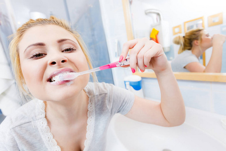 女人在浴室清洗刷牙