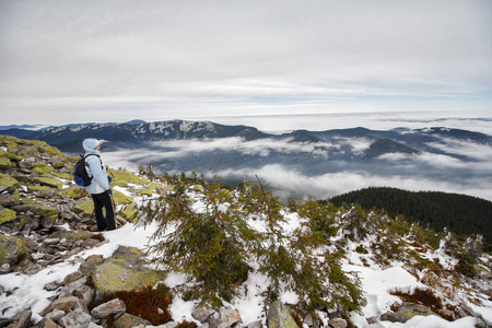 在白雪覆盖的山的背景下, 女孩是一个背包客。喀尔巴阡山