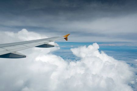 一架飞机在云层上方飞行的窗户看到。 商业概念。