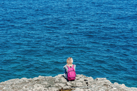 意大利, 阿普利亚 Polignano, 背包女游客在蓝海附近放松