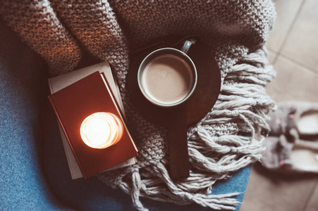 在家度过舒适的冬季周末。 早上用咖啡或可可书温暖的针织毯和北欧风格的椅子。 海格概念。