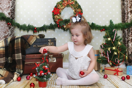 小女孩坐在一棵圣诞树