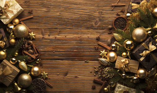圣诞装饰概念。 金色的鲍布和圣诞香料都在一个乡村木制背景与复制空间。