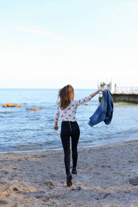 幸福的年轻女人喜欢阳光明媚的天气和岸上的 bl 摆姿势