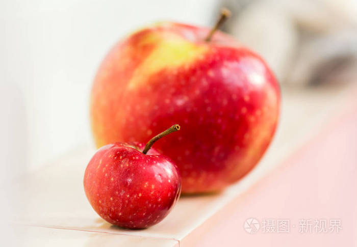 照片 一个大苹果背景上的小天堂苹果. 妈妈有个孩子. 大小比较.jpg