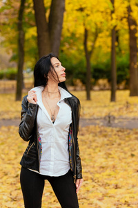 一个美丽的年轻女孩的肖像走在一个秋天公园