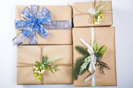 优雅的圣诞礼品盒呈现在牛皮纸, 新年装饰白色。圣诞贺卡背景