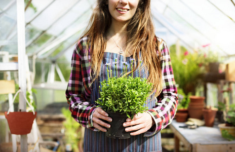 女人在家里的花园里举行植物