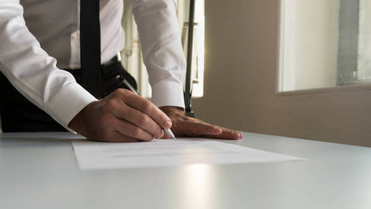 在办公室签署合同文件或法律文件的商人
