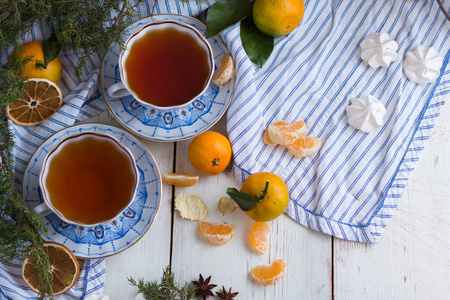 圣诞节早上好饮茶。用橘子和两杯热茶的美丽静物