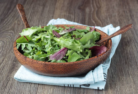 新鲜的夏季绿色沙拉与生菜叶，菊苣，玉米沙拉和萝卜，在一个在桌子上。 健康的饮食观念。