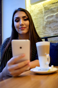 女孩在咖啡馆与智能手机