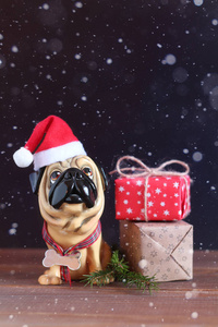 一只狗戴着圣诞帽在木桌上的身影。 明年的象征
