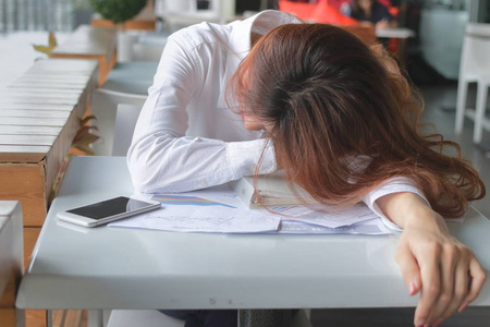 沮丧的强调年轻的亚洲商业妇女感到严重和疲倦与她的工作在办公室