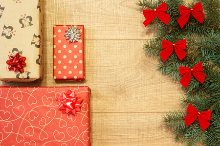 新年圣诞礼物在包装树上，木制背景模板上有红色蝴蝶结
