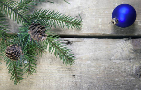 圣诞节和新年概念。木板上有圆锥形和蓝色新年球的Fir树枝，俯视图，平拉