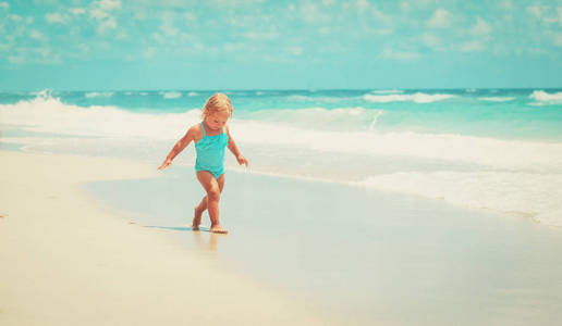 运行游戏与波在海滩上的小女孩