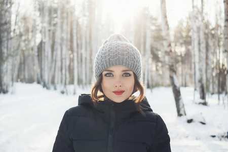 年轻漂亮的女孩在白色冬季森林