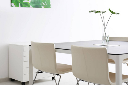 现代办公室内部有大桌子和白色椅子