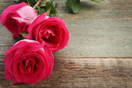 木制桌子上漂亮的粉红色玫瑰