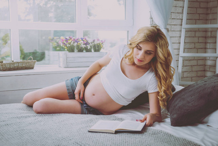 年轻的孕妇在看书