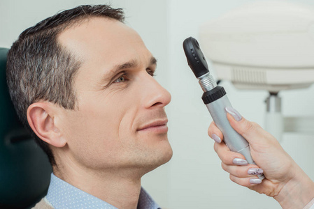 眼科医生做眼科检查的男性侧视图
