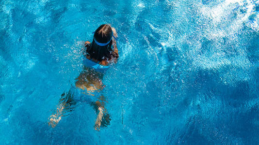 从热带度假概念之上的泳池水中少女的鸟瞰图