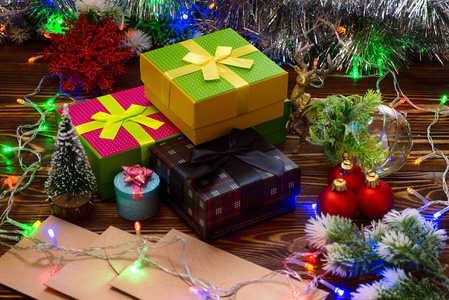 圣诞作文新年概念礼物和节日装饰。 盒子的惊喜灯球，圣诞树的树枝在木制的背景上颠簸。