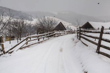 村庄的全景在冬天的山上覆盖着雪。 冬季景观。 自由和孤独的概念。