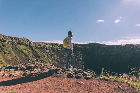 带背包的小胡子男子侧视冰岛风景优美的火山口湖