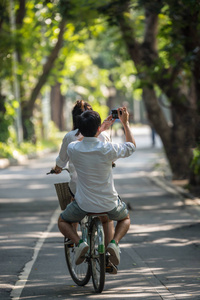 夫妇自行车自行车使用相机在公园