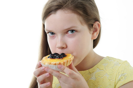 一个年轻女孩吃蛋糕的形象。 白色背景