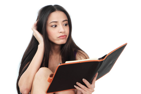 年轻的女人看着黑色的书图片
