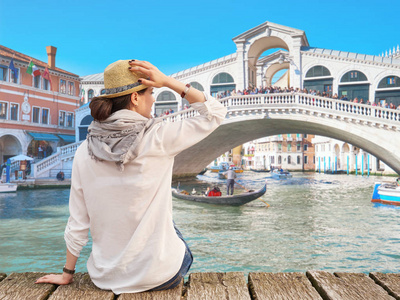 妇女旅行者在帽子享受夏天时间, 在背景的交易所桥梁, 威尼斯