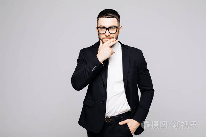 黑色西装,领带摸下巴,灰色背景下的严肃时髦帅气男子肖像