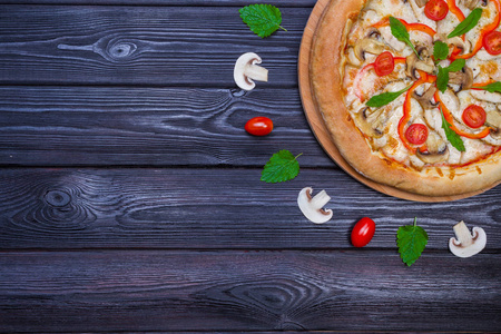 自制披萨配西红柿黑木桌上看