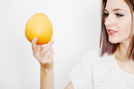 女人手里拿着葡萄柚。 带柑橘的年轻女人。