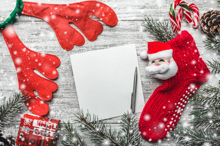 圣诞激励主题一个记事本和一支笔，带有文字装饰的空间，用杉木手工制作的圣诞礼物盒装在木制背景上，从上面的贺卡上看到雪中送炭