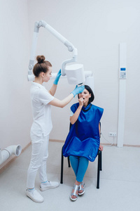 牙医为牙科诊所的年轻妇女制作X射线图像。 瞄准牙科X线摄影。