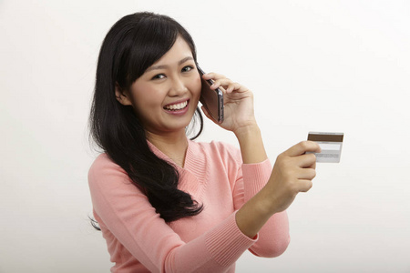 亚洲女人用智能手机付款图片