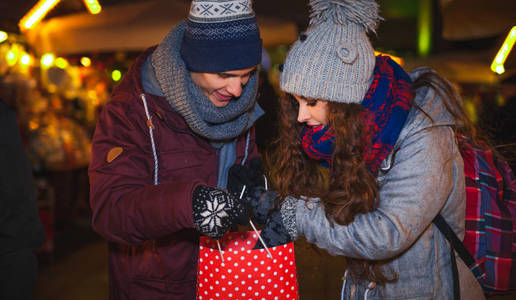 情侣购物袋在传统的圣诞市场, 假日购物
